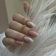 a woman's hand with white and gold manies on her nails, in front of a fur