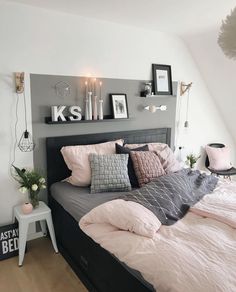 a bed with pink and grey sheets in a bedroom