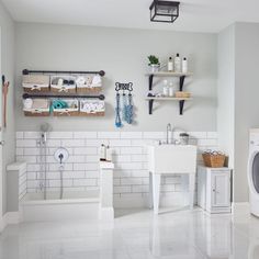 a washer and dryer in a room with white tile flooring on the walls