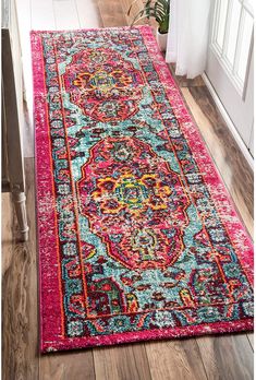 a bright pink rug with an ornate design on the floor in front of a door