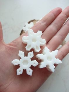 three snowflakes are shown in the palm of someone's hand