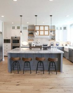 a kitchen with an island and three stools in front of the countertop area