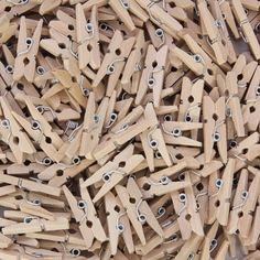 a pile of wooden clothes pegs with eye holes