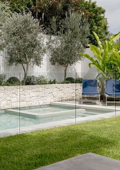 an empty swimming pool surrounded by grass and trees