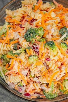 a glass bowl filled with pasta salad and broccoli