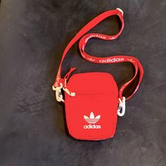 Great Versatile Nwot Red Fabric Adidas Crossbodyfanny Pack W Detachable Strap. 1 Outside Zipper Pocket1 Outside Slip Pocket1 Inside Zip Slip Pocket. Approximately 7” In Length5” Wide Easy Zipper Opening/Closing. White Accents. Noticed A Small Mark On Side Of Bag Near Zipper. See Last Picture. It’s Really Not Noticeable. Thanks So Much For Looking & Bid With Confidence Casual Red Shoulder Bag With Mobile Phone Holder, Red Functional Mobile Phone Bag, Trendy Red Nylon Shoulder Bag, Casual Red Bag With Cell Phone Pocket, Red Nylon Bag With Pockets, Red Nylon Bags With Pockets, Sporty Red Bag For Streetwear, Casual Red Nylon Shoulder Bag, Adidas Belt Bag