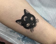 a black cat tattoo on the arm