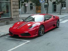 a red sports car is parked on the street