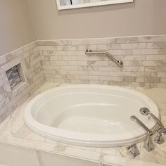 a white bath tub sitting inside of a bathroom