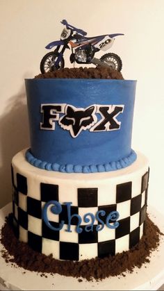 a cake that is decorated like a motorcycle and dirt on the bottom with words fox chase