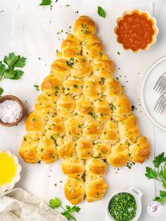 a christmas tree made out of bread on top of a cutting board next to other food