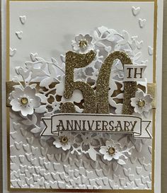 a white and gold anniversary card with flowers