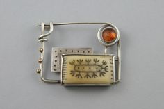 A rectangular pin made from silver, amber,  tagua nut and bronze. The design carved into the tagua is inspired by tattoos worn by Croatian women at the turn of the 20th century, Croatian Tattoo, Tagua Nuts, Safety Pins, The 20th Century, Safety Pin, Metal Working, Jewelry Inspiration, Brooches, 20th Century