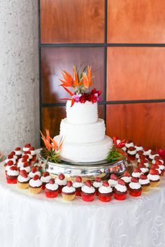 a wedding cake and cupcakes on a table