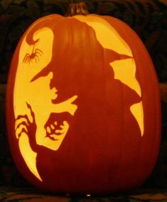 a carved pumpkin with the silhouette of a witch on it