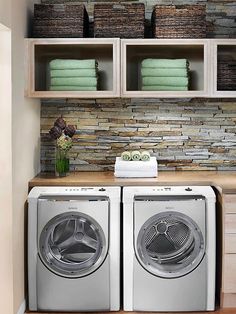 a washer and dryer in a laundry room with stacked towels on the shelves