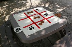 a dog themed picnic table with paw prints on it and red tape across the top