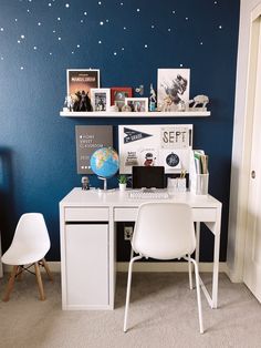 a white desk sitting under a blue wall