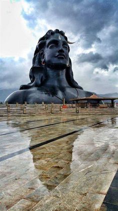 the large statue is reflecting in the water