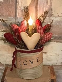 a candle that is sitting in a vase with some hearts on the side and love written on it