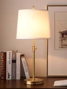 a lamp is sitting on a desk next to books and an open bookcase in front of it