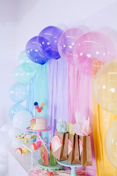 a table topped with lots of balloons and cake