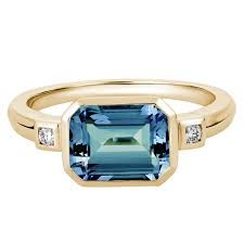 Emerald Cut Blue Topaz Ring with Diamond Side Stones in Yellow Gold | Borsheims Blue Topaz Jewelry, Lavender Quartz, Colored Stone Rings, Emerald Cut Rings, Topaz Engagement Ring, Topaz Jewelry, London Blue Topaz Ring, Swiss Blue Topaz, Yellow Gold Ring