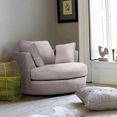 a living room with a chair and pillows on the floor