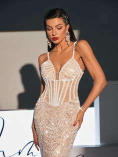 a woman in a white dress walking down a runway