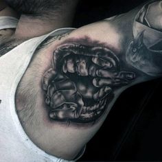 a man's arm with a black and white tattoo design on the left shoulder