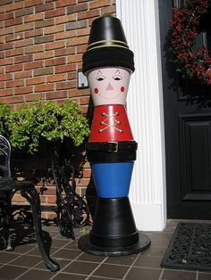 a toy soldier sitting in front of a brick building with the words how to make a clay pot soldier