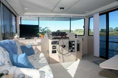 the inside of a boat that is on the water with lots of windows and couches