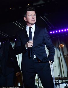 a man in a suit and tie holding a microphone