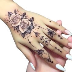 a woman's hand with tattoos and flowers on it