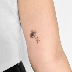 a small sunflower tattoo on the left arm