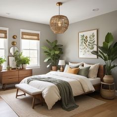 a bed sitting in a bedroom next to two windows with potted plants on them