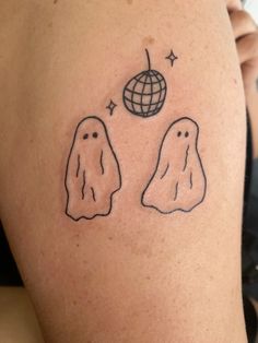 a woman with a tattoo on her arm that has two ghost faces and a globe