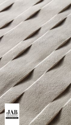 an up close view of the top of a rug with wavy lines in grey and white