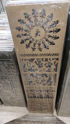 an intricately designed wooden door in the middle of a room with several pieces of wood stacked on top of each other