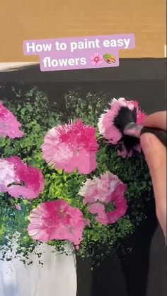 someone is painting flowers in a vase with pink and white flowers on the bottom half