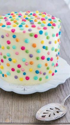 a cake with white frosting and multicolored sprinkles on it