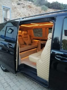 the inside of a black van with its doors open and seats folded down in front of it