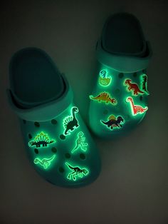 Dinosaur Glow in the dark charms for all dinosaur lovers. Charms must be exposed to light to absorb energy to enable it glow. Place under flourescent light for a few second and watch your charms glow in the dark. Personalize you Crocs or Croc-like shoes and silicone bracelets with these stylish shoe charms. How to order. List the alphabet at the top of each charm in the personalization tab. Each charm is *Individually sold. Shoes are not included! Size: Varies between each charm. Measures about Jibits For Crocs, Dinosaur Merch, Croc Charms Ideas, Glow In The Dark Clothes, Dinosaur Accessories, Dinosaur Things, Glow In The Dark Shoes, Dinosaur Clothes, Dinosaur Stuff