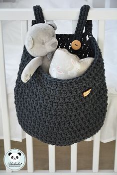 a crocheted bag with a stuffed animal in it is hanging from the ceiling