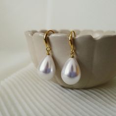 "Free shipping on orders over $35.00  [North America ONLY].  The 14K-Gold-Plated Water Drop Pearl Dangle Earrings are a stunning and timeless accessory that will add elegance to any outfit. The earrings feature a water drop shaped design plated with 14K gold that glistens beautifully in the light. Suspended from the gold plating is a luxurious, white imitation pearl that adds a touch of sophistication to the earrings. The earrings dangle delicately from the ear, making them the perfect addition to any special occasion or everyday look. The 14K-Gold-Plated Water Drop Pearl Dangle Earrings are versatile, lightweight, and easy to wear, making them an ideal choice for any jewelry collection. With their classic design and exquisite materials, these earrings are sure to become a staple piece in