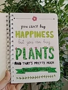 someone holding up a spiral notebook that says, you can't buy happiness but you can buy plants and that's pretty much