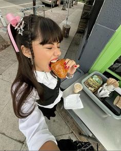 a young woman eating food from a tray