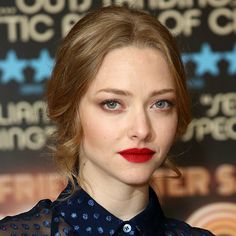 a woman with red lipstick is posing for the camera