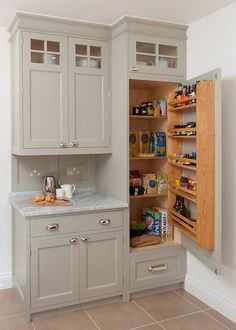 an open cabinet in the corner of a kitchen with lots of cupboards and shelves