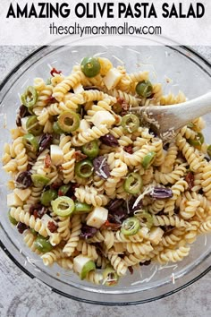 a glass bowl filled with pasta and olives